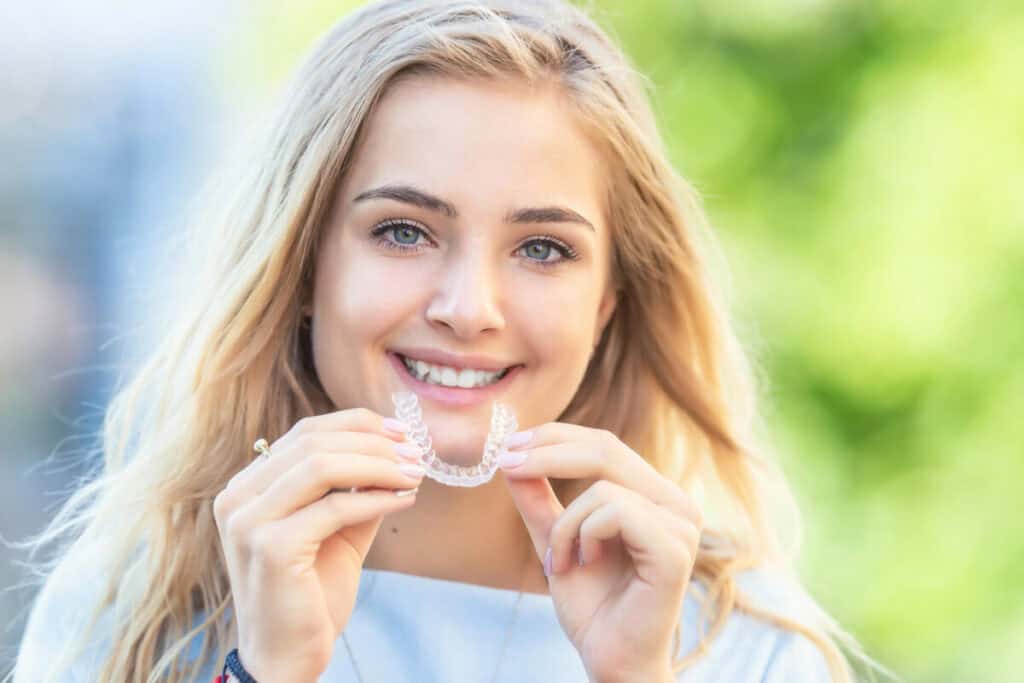 Woman holding invisalign clear aligners