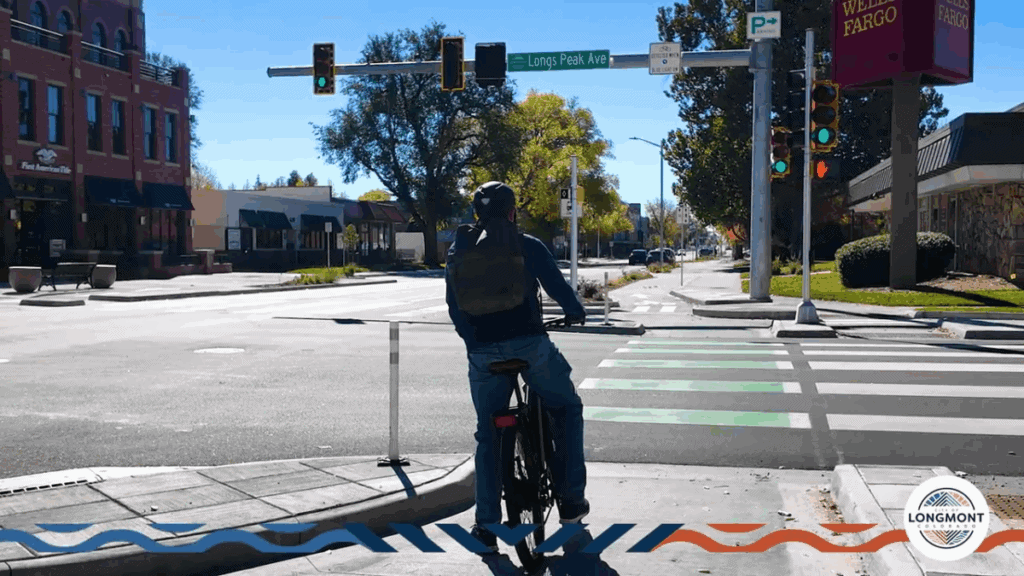 Cyclist waiting at the corner island holding area facing the intersection ready to make a two-stage left turn