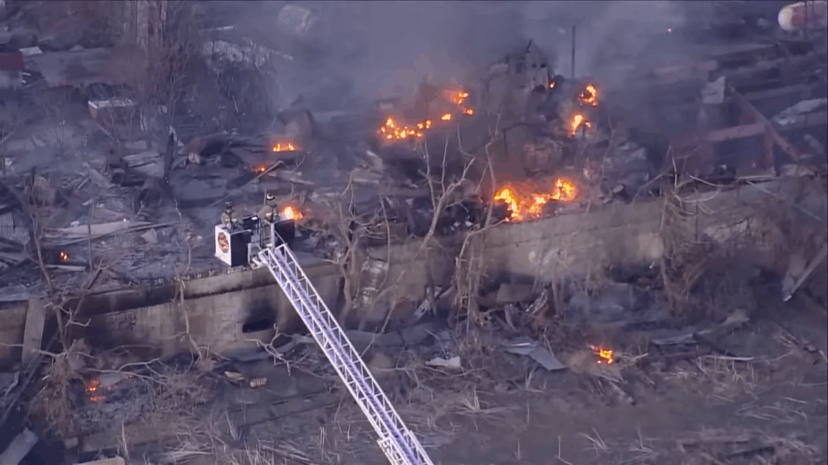 Aerial view of active flames and firefighters at the burned sugar mill ruins