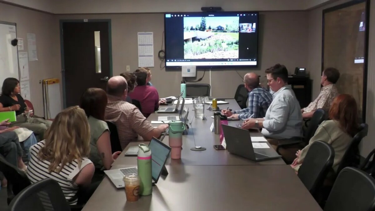 Meeting room screen showing photos of a vegetated waterway